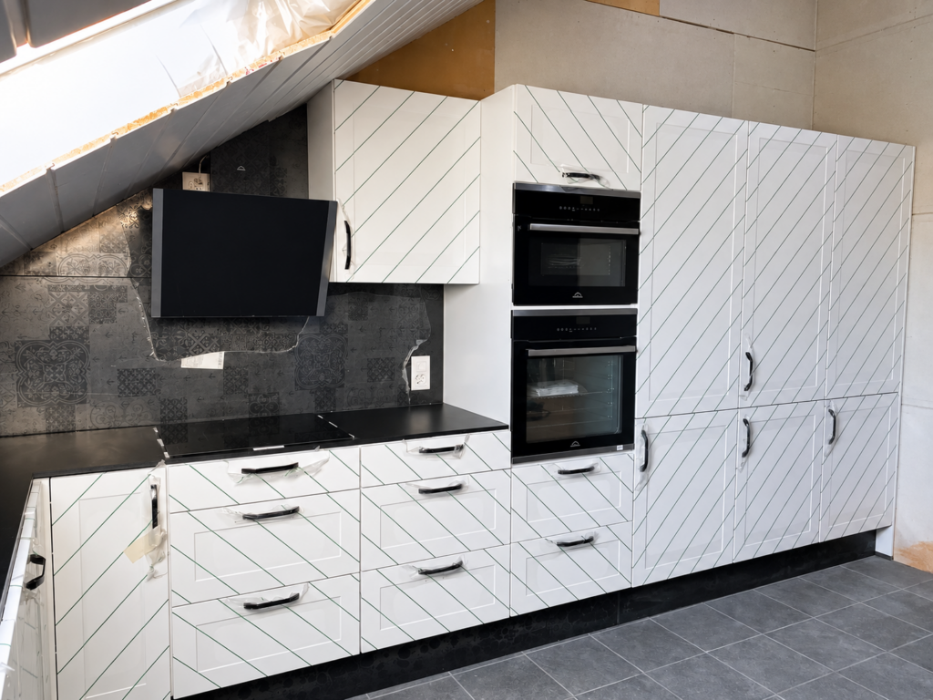 Cuisine blanche réalisée par Atelier Art Home, façades sans poignée et plan de travail noir