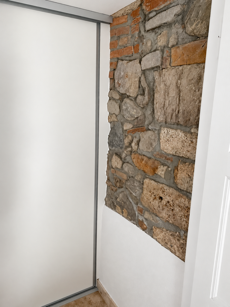 Porte coulissante blanche et mur en pierres apparentes – Atelier Art Home